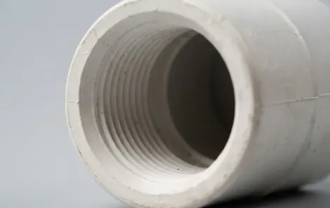 Detalle de la rosca interior de una conexión PVC blanca